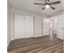 Spacious bedroom with hardwood floors, white closet, and ceiling fan at 2149 S Olivewood --, Mesa, AZ 85209