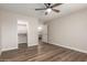 Bright bedroom features wood-look flooring, a ceiling fan, and natural light from a window, enhancing the room's appeal at 2149 S Olivewood --, Mesa, AZ 85209