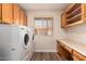 Laundry room featuring wood cabinets, a countertop, and modern appliances at 2149 S Olivewood --, Mesa, AZ 85209