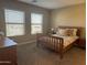 Bedroom with a wooden-frame bed, a dresser, and two windows for natural light at 2150 W Alameda Rd # 1119, Phoenix, AZ 85085