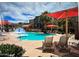 A community pool is furnished with lounge chairs under umbrellas, and nearby apartments at 2150 W Alameda Rd # 1119, Phoenix, AZ 85085