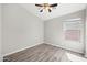 Clean and bright bedroom with hardwood floors, a ceiling fan, and a large window at 21867 N Kirkland Dr, Maricopa, AZ 85138