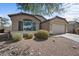 Inviting front exterior featuring desert landscaping, a large window, and a two-car garage at 21867 N Kirkland Dr, Maricopa, AZ 85138