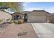 Charming front exterior of a single-story home with desert landscaping and a two-car garage at 21867 N Kirkland Dr, Maricopa, AZ 85138