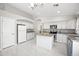 Well lit kitchen with central island, stainless steel appliances, and white cabinets at 21867 N Kirkland Dr, Maricopa, AZ 85138