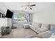 Living room with a large picture window, a ceiling fan, and an oversized sectional sofa at 21867 N Kirkland Dr, Maricopa, AZ 85138