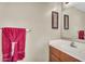 Cozy bathroom featuring a wooden vanity with a mirror and a red towel hanging on the rack at 24848 W Kowalsky Ln, Buckeye, AZ 85326