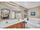 Bright bathroom with double sinks, bathtub, shower and a large mirror at 24848 W Kowalsky Ln, Buckeye, AZ 85326