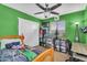 Bedroom with vibrant green walls, a ceiling fan, and a cozy bed with a colorful blanket at 24848 W Kowalsky Ln, Buckeye, AZ 85326