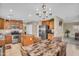 An open concept eat-in-kitchen offers tile floors, a center island, and stainless steel appliances at 24848 W Kowalsky Ln, Buckeye, AZ 85326