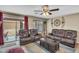 Relaxing living room with leather furniture, sliding glass doors, and a ceiling fan for comfort at 24848 W Kowalsky Ln, Buckeye, AZ 85326