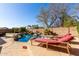 Resort-style pool with rock waterfall, lush landscaping, and comfortable lounge seating at 2830 E Janelle Way, Gilbert, AZ 85298