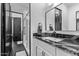 Modern bathroom with black marble counters, and white cabinets, with a walk-in shower at 29501 N 76Th St, Scottsdale, AZ 85266