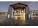 Striking home featuring a porte-cochere with stone pillars and desert landscaping at twilight at 29501 N 76Th St, Scottsdale, AZ 85266