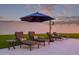 Relaxing lounge chairs under a blue umbrella create an inviting outdoor space at 29501 N 76Th St, Scottsdale, AZ 85266