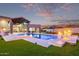 Exterior view of backyard pool with fire features, green lawn, and luxurious seating at 29501 N 76Th St, Scottsdale, AZ 85266