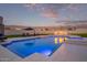 Backyard pool featuring lounge chairs, an umbrella, and eye-catching fire features at dusk at 29501 N 76Th St, Scottsdale, AZ 85266