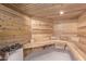 Inviting cedar sauna with wood benches, a hot rock heater, and traditional wooden bucket at 29501 N 76Th St, Scottsdale, AZ 85266