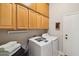 Well-lit laundry room featuring upper cabinets and modern washer and dryer units at 3482 E Cotton Ln, Gilbert, AZ 85234