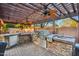 Outdoor kitchen equipped with stainless steel appliances, stone accents, and a shaded pergola at 3482 E Cotton Ln, Gilbert, AZ 85234