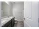 Bathroom featuring dark cabinets, granite countertops, a large mirror, and a shower-tub combo at 35680 W Mallorca Ave, Maricopa, AZ 85138