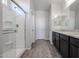 Modern bathroom showcasing a glass-enclosed shower and a dark wood vanity with granite countertop at 35680 W Mallorca Ave, Maricopa, AZ 85138