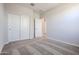 Bedroom featuring neutral walls, carpeted floors, closet with sliding doors, and an open doorway at 35680 W Mallorca Ave, Maricopa, AZ 85138