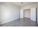 This bedroom features gray wood-look tile flooring and an open doorway to another room at 35680 W Mallorca Ave, Maricopa, AZ 85138