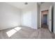 Bedroom featuring neutral walls, carpeted floors, closet with sliding doors, and an open doorway at 35680 W Mallorca Ave, Maricopa, AZ 85138