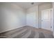 Bedroom featuring neutral walls, carpeted floors, closet with sliding doors, and a doorway at 35680 W Mallorca Ave, Maricopa, AZ 85138