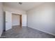 This bedroom features gray wood-look tile flooring and an open doorway to another room at 35680 W Mallorca Ave, Maricopa, AZ 85138