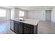 Modern kitchen island features a stainless steel sink, granite countertops, and sleek dark wood cabinetry at 35680 W Mallorca Ave, Maricopa, AZ 85138