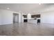 Open-concept living area with tile floors connected to a modern kitchen at 35680 W Mallorca Ave, Maricopa, AZ 85138