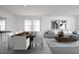 Bright open-plan living room with dining table, and sleek modern sectional, and neutral colors at 3983 E San Jose St, San Tan Valley, AZ 85143