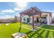 Beautiful backyard with artificial turf, a wooden pergola, patio furniture, and space for outdoor games at 40160 W Hensley Way, Maricopa, AZ 85138