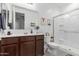 Well-lit bathroom with a dark wood vanity, large mirror, and glass-enclosed shower offering modern amenities at 40160 W Hensley Way, Maricopa, AZ 85138