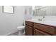 Bathroom featuring a white sink, toilet and dark wood vanity, complimented by minimalist decor and bright lighting at 40160 W Hensley Way, Maricopa, AZ 85138