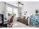 Bright bedroom features a bed, ceiling fan, stylish furniture and a large window providing natural light at 40160 W Hensley Way, Maricopa, AZ 85138