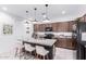 Bright kitchen boasting granite countertops, a central island with barstool seating, and modern lighting at 40160 W Hensley Way, Maricopa, AZ 85138