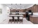 Modern kitchen featuring granite countertops, a central island with seating, and stainless steel appliances at 40160 W Hensley Way, Maricopa, AZ 85138