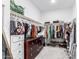 Organized walk-in closet featuring ample hanging space, shelving, and a dark wood dresser with decorative pulls at 40160 W Hensley Way, Maricopa, AZ 85138