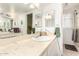 A well-lit bathroom with a sink, large mirror, and vanity with neutral countertops at 4111 W Hayward Ave, Phoenix, AZ 85051