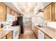 A bright kitchen with wood cabinets, white appliances, and an adjoining space with more cabinets at 4111 W Hayward Ave, Phoenix, AZ 85051