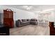 Bright living area with wood-look floors, a comfortable gray sofa, and ample natural light at 4111 W Hayward Ave, Phoenix, AZ 85051