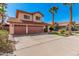 Front exterior of a two-story home featuring a three-car garage, tile roof and desert landscaping at 4931 E Paradise Ln, Scottsdale, AZ 85254