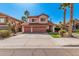 Two-story home with a three-car garage, tile roof, palm trees, and a well-kept lawn at 4931 E Paradise Ln, Scottsdale, AZ 85254