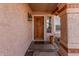 Charming front entrance with a wooden door, decorative lantern, and textured wall finish at 4931 E Paradise Ln, Scottsdale, AZ 85254