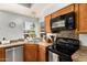 Cozy kitchen highlighting stainless steel appliances, warm wood cabinetry, and a view of the backyard at 4931 E Paradise Ln, Scottsdale, AZ 85254