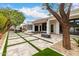 Expansive backyard featuring a tiled patio with artificial grass accents, mature trees, and modern outdoor living at 5127 N 71St St, Paradise Valley, AZ 85253