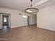 Open dining area with wood-look tile flooring, stylish chandelier, and a view into adjoining rooms with abundant natural light at 520 W Gibraltar Ln, Phoenix, AZ 85023